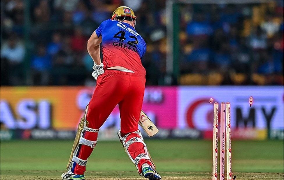 Royal Challengers Bengaluru's Cameron Green is clean bowled by Lucknow Super Giants' Mayank Yadav during the Indian Premier League (IPL) Twenty20 cricket match between Royal Challengers Bengaluru and Lucknow Super Giants at the M Chinnaswamy Stadium in Bengaluru on April 2, 2024.