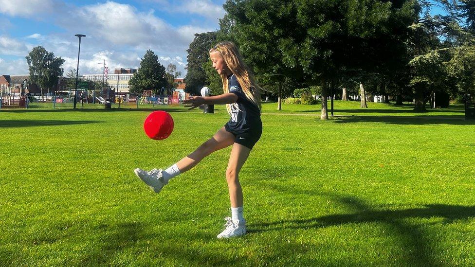 Lola playing football in a park