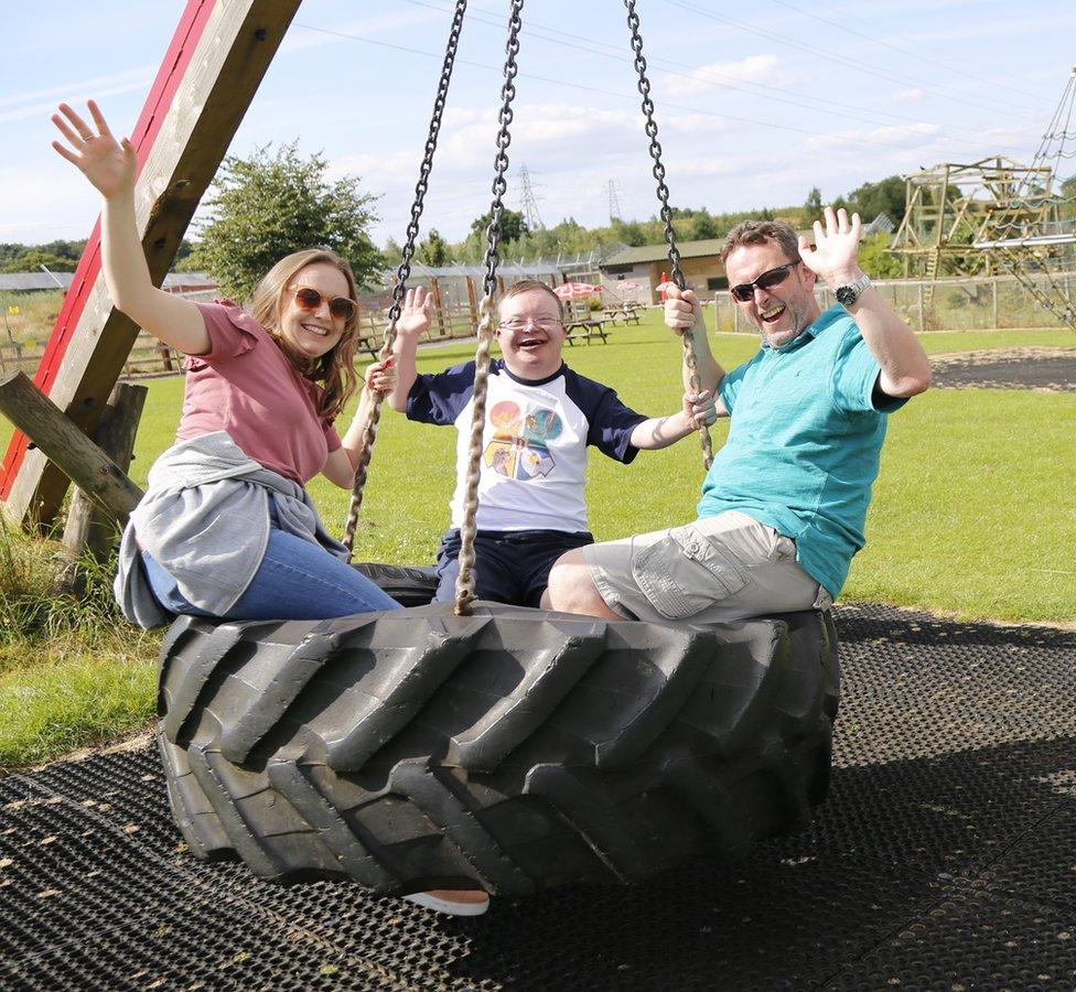 Three people on a big tyre swing - Paul Fears is on the right, his disabled son Greg in the middle and his daughter Megan on the left