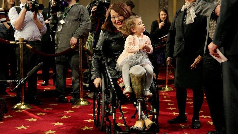 Senator Tammy Duckworth (D-IL) carries her daughter Abigail