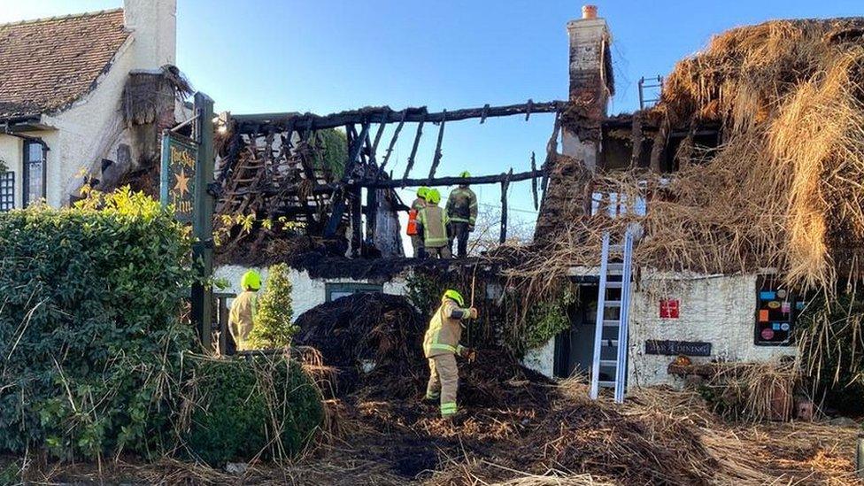 Damaged thatched roof and gutted building