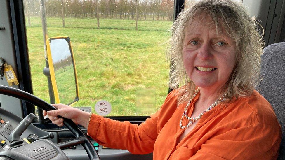 Instructor Sue Howe at the steering wheel of a training bus