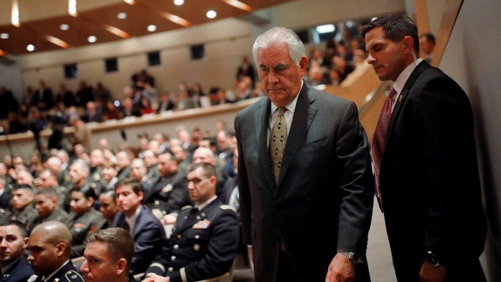 Rex Tillerson is led into auditorium by security