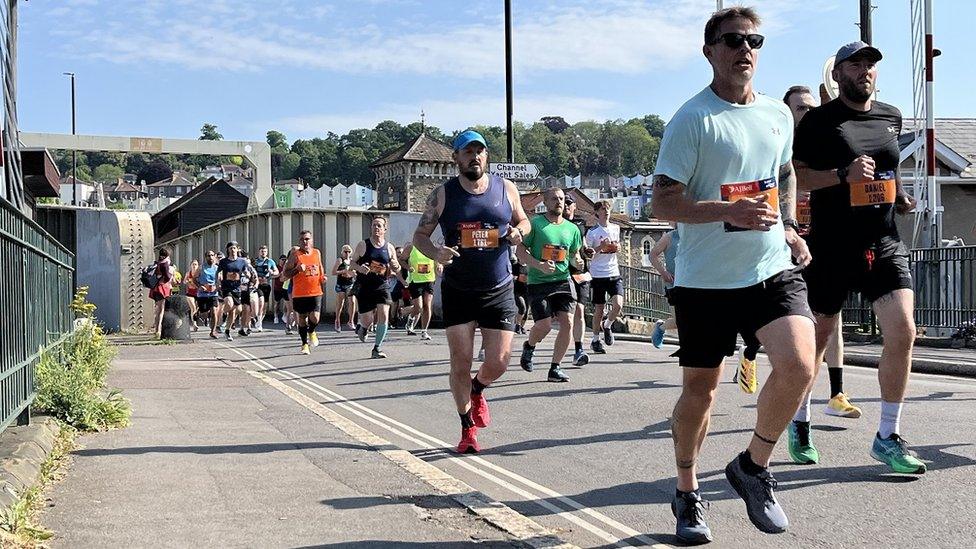 Runners cross a swing bridge as part of the Bristol 10k 2024