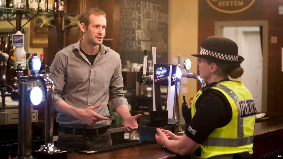 Glasgow bar manager Paul Banham talks to a police officer