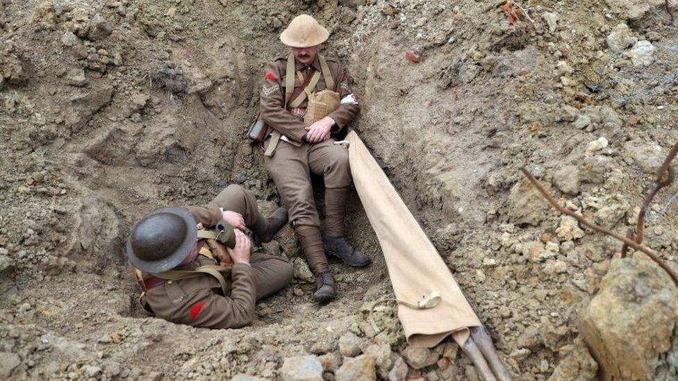 World War One re-enactors sit in the "Passchendaele Landscape", a recreation of the 1917 conditions on the battlefield at the Passchendaele Memorial Park in Zonnebeke