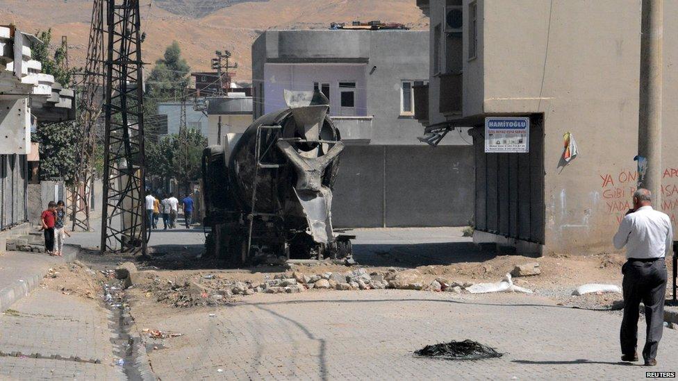 A burned vehicle is seen on a road in town of Cizre in Sirnak province, near the border with Syria, Turkey (28 August 2015)