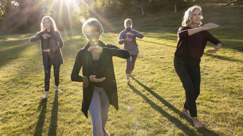 Women practising tai chi outdoors