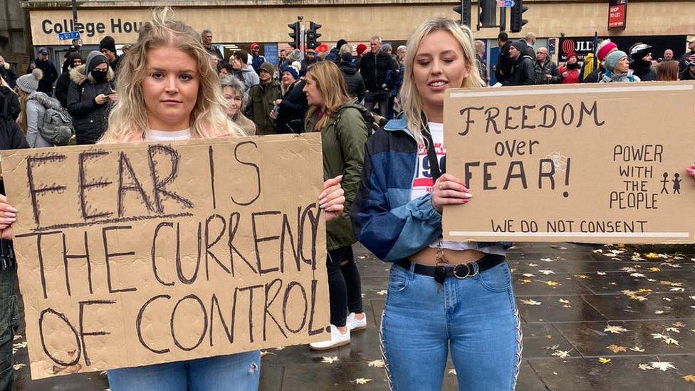 Anti-lockdown protesters holding placards on College Green in Bristol