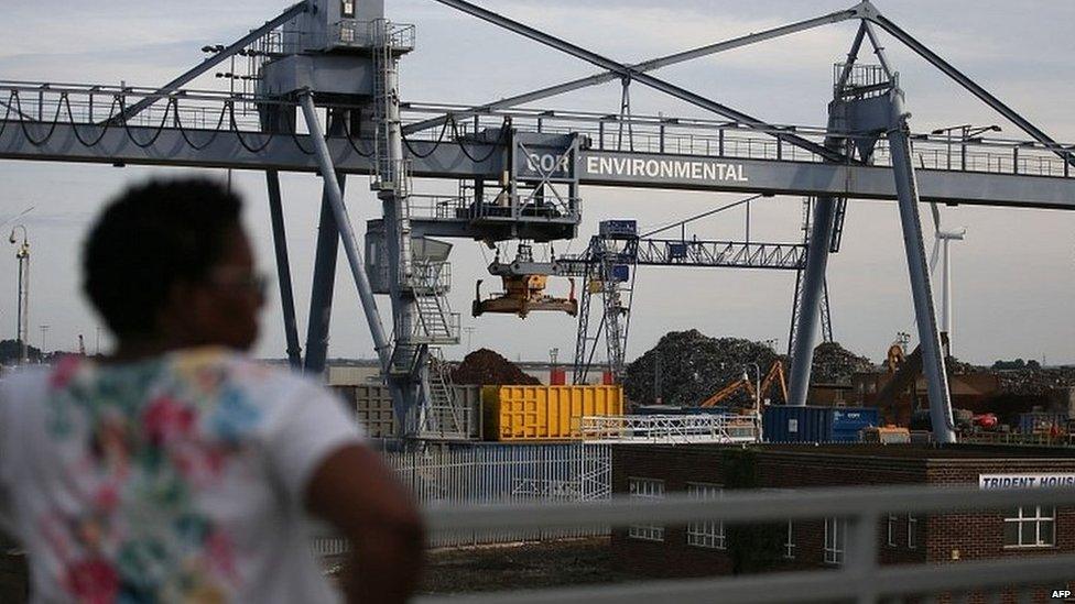 A woman overlooks port works in the town of Tilbury