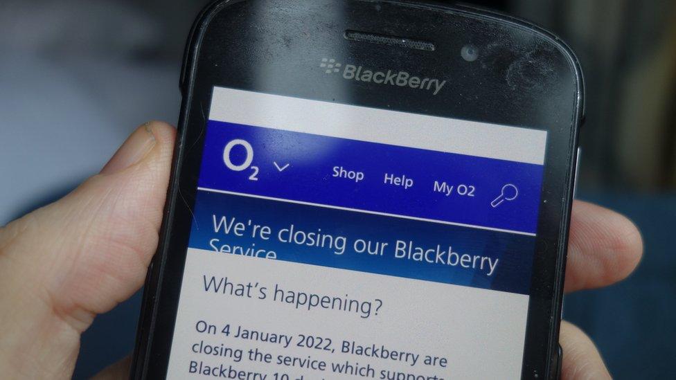 A photo of the author with his phone. The screen displays a message that service will be ending.