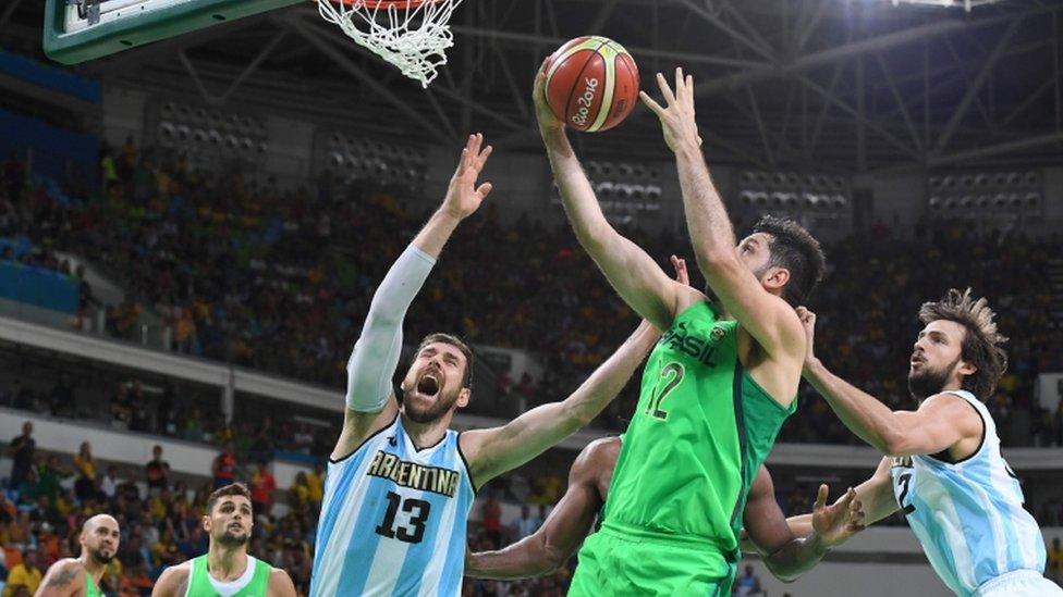 Argentina's small forward Andres Nocioni (L) and Brazil"s power forward Guilherme Giovannoni (R)
