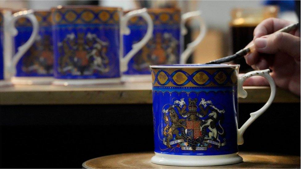 A worker paints the finish on official chinaware at a pottery factory in Stoke-on-Trent