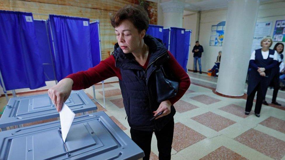 A woman casts her ballot at a polling station during a referendum on the joining of the self-proclaimed Donetsk People's Republic to Russia, in Donetsk, Ukraine