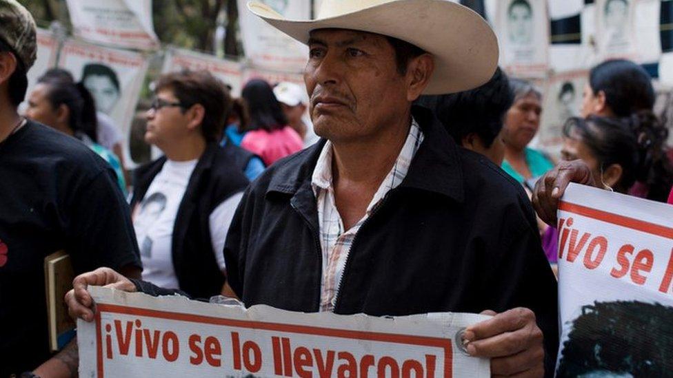 Relatives of 43 missing students from the Isidro Burgos rural teachers" college hold pictures of their missing loved ones after meeting with Attorney General Arely Gomez Gonzalez in Mexico City, Thursday, March 17, 2016.