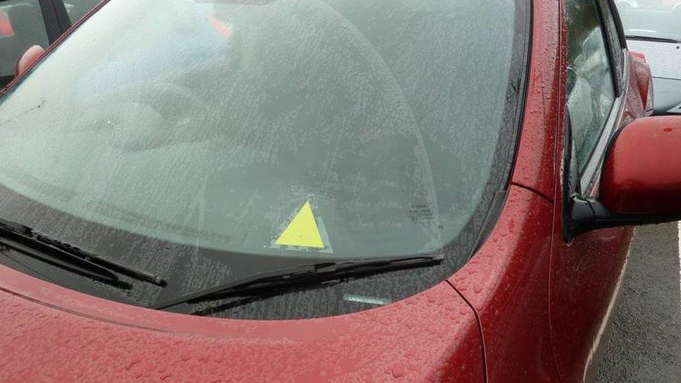 A picture of the yellow triangle on a car window to alert emergency teams to a driver's medical advice