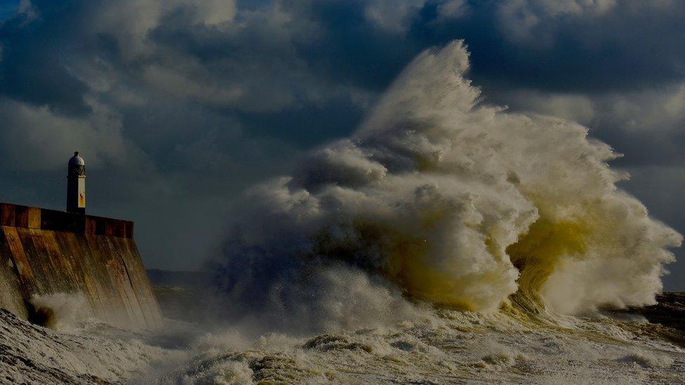 Huge wave crashing near a lighthouse in Porthcawl, Bridgend