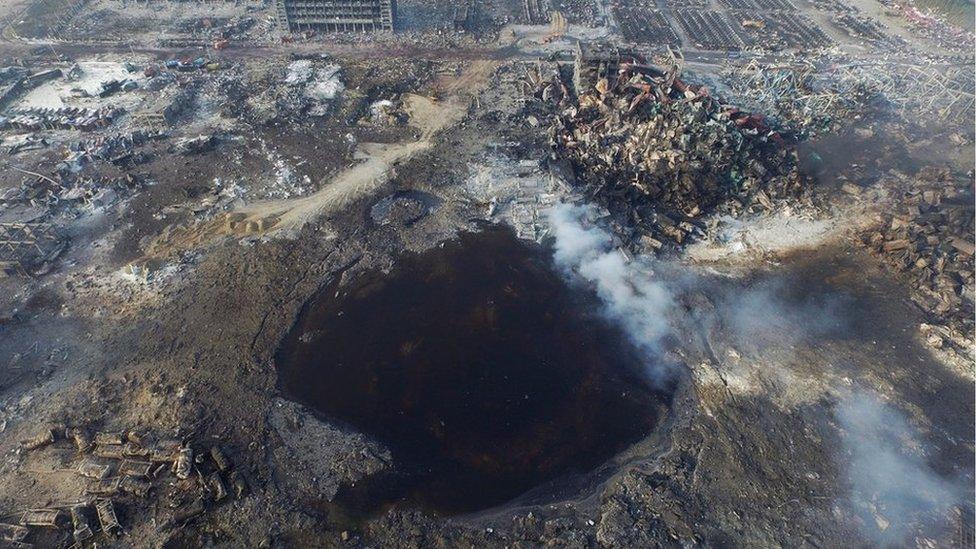 An aerial view on 15 August, 2015, of a large hole in the ground in the aftermath of a huge explosion that rocked the port city of Tianjin, China