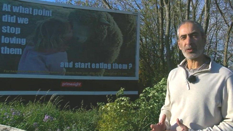 Tony Galuidi in front of vegan poster