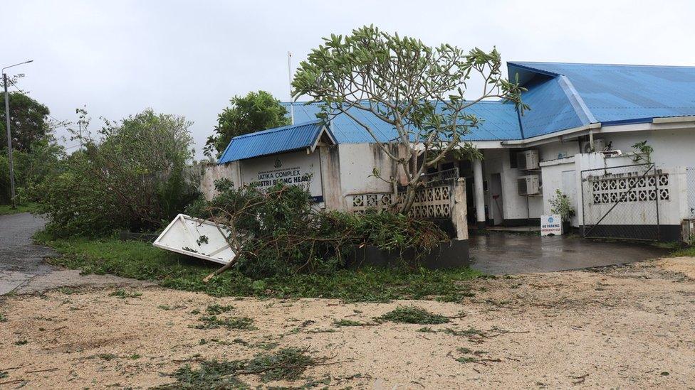 A house sinking into muddy water after being hit by Cyclone Judy