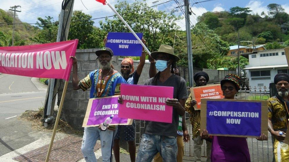 Protesters with with banners protesting against British colonialism as the Earl and the Countess of Wessex arrive at Government House in St Vincent and the Grenadines,