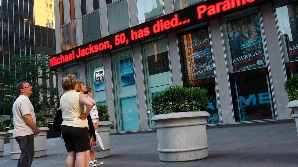 People in New York learn the news on a screen