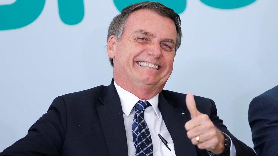 Brazil's President Jair Bolsonaro gives a thumbs up during a ceremony in Brasilia