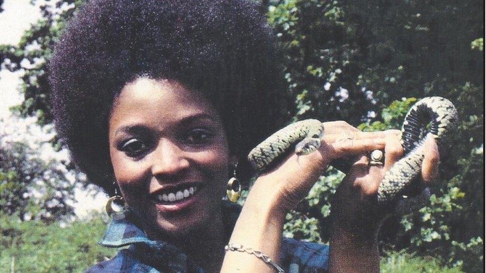 Peaches Golding holding a snake