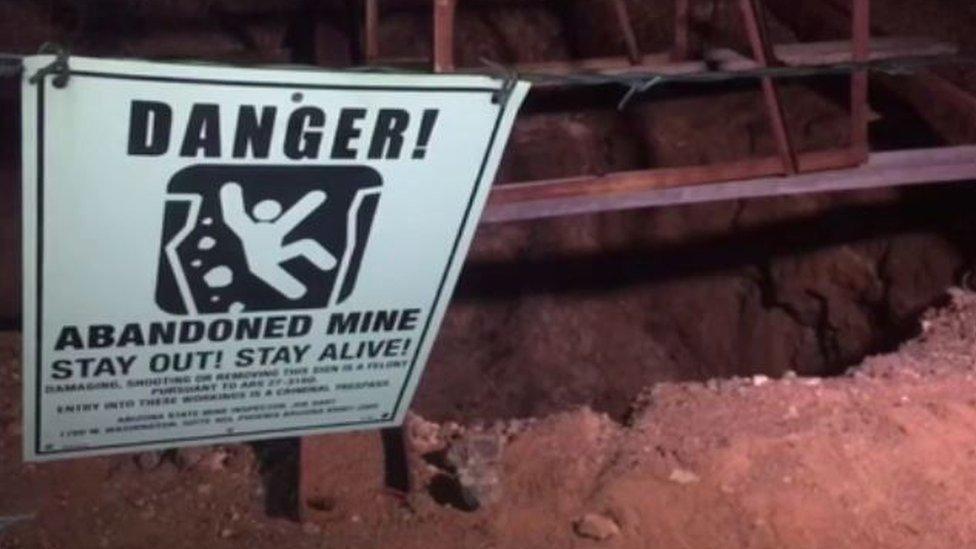 a sign warns people away from the abandoned mine shaft