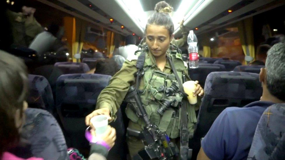 Israeli soldier hands out water during Syria White Helmets extraction from Golan Heights, 22 July 2018