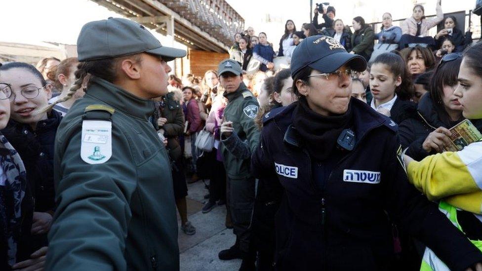 Israeli policewomen hold back Ultra Orthodox Jewish girls gathering at Judaism's holiest prayer site of the Western Wall in the Old City of Jerusalem on 8 March 2019