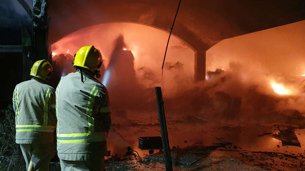 Firefighters hosing burning building