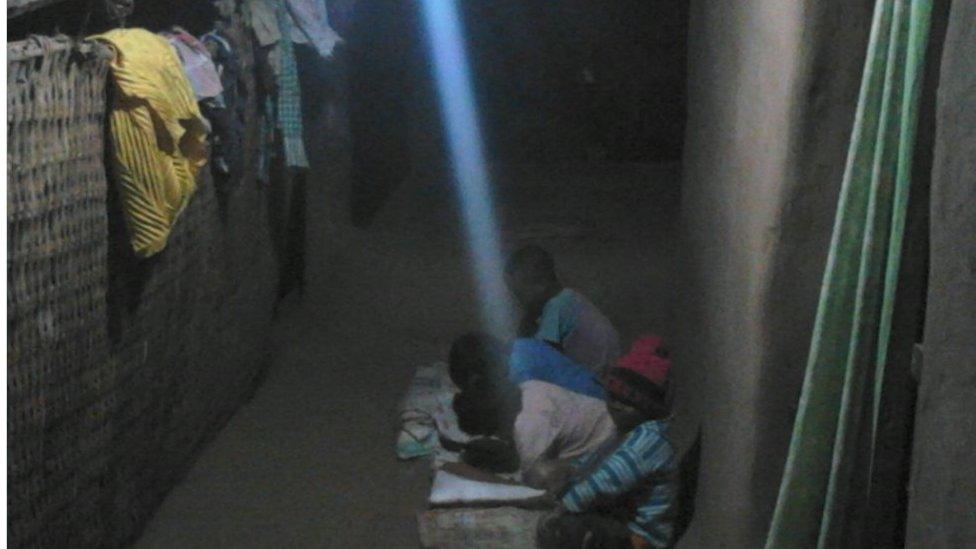 Village children study under electric light