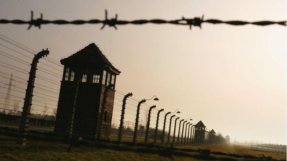 Image of Auschwitz watchtower, barbed wire and fencing