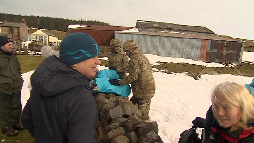 Residents receive supplies from soldiers