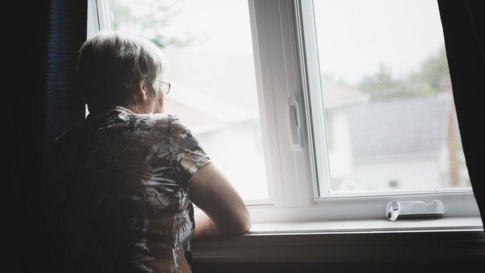 a lonely woman looking out of a window