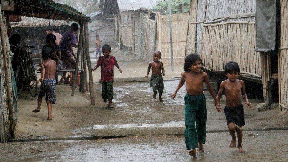 Rohingya children play during rain at an Internally Displaced Persons (IDPs) camp near Sittwe of Rakhine State, western Myanmar, 22 March 2016