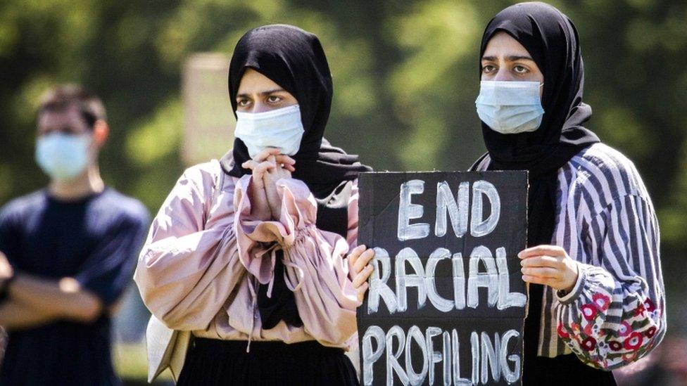 Veiled women hold a placard as supporters and members of the Dutch action group "Kick Out Zwarte Piet" (KOZP) from The Hague stage their second demonstration this month at the Malieveld in The Hague