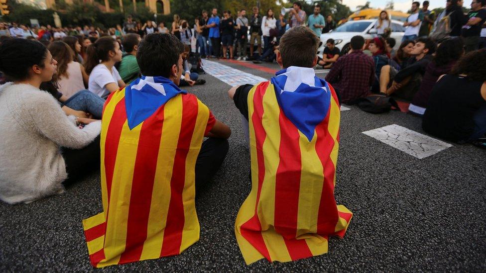 Students wear Catalan separatist flags as they block a street during a gathering to protest against the imprisonment of leaders of two of the largest Catalan separatist organizations, in Barcelona, Spain, October 17, 2017