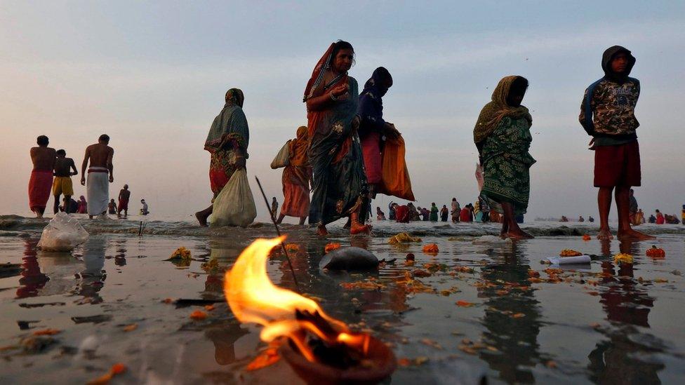 Hindu pilgrims walk after taking a dip at the confluence of the river Ganges and the Bay of Bengal a day after "Makar Sankranti" festival at Sagar Island, south of Kolkata, India, on 15 January 2017