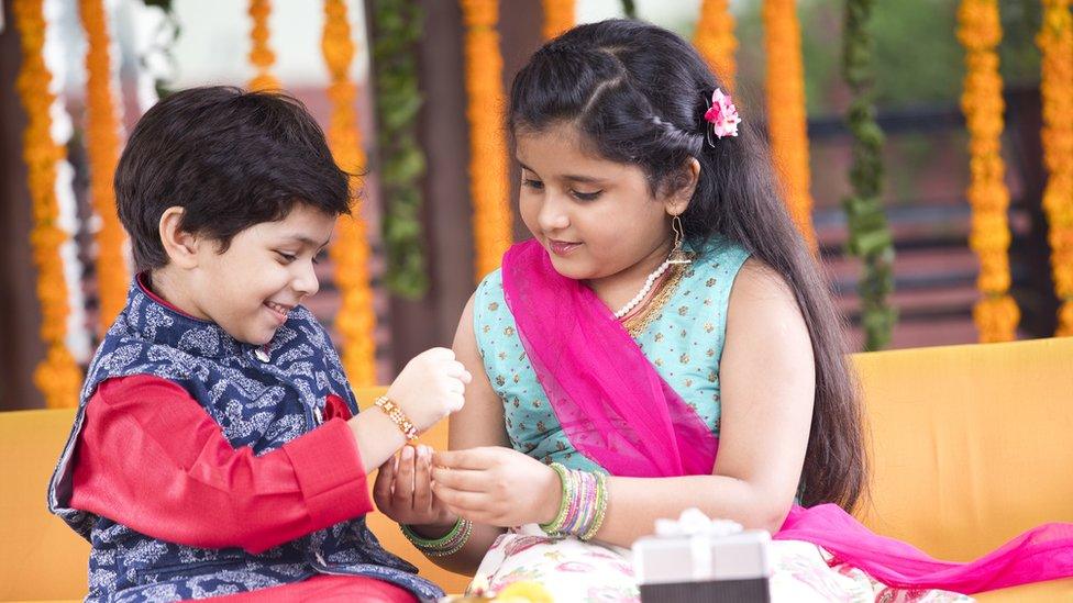 girl trying a bracelet to boy's wrist