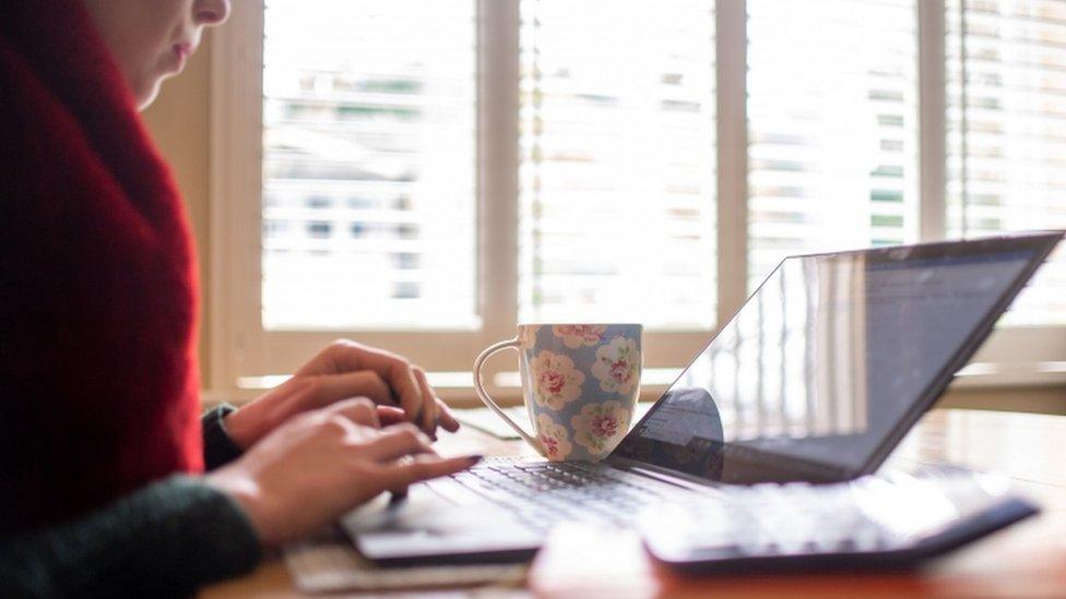 A woman typing on her laptop