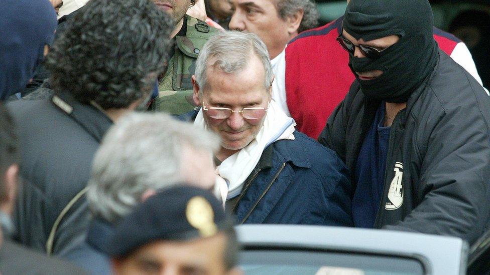 Mafia boss Bernardo Provenzano with hooded police officers after his capture in Palermo, Sicily, southern Italy, 11 April 2006