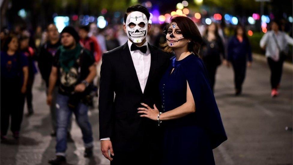 A couple pose for a photo during the Catrinas parade in Mexico City.