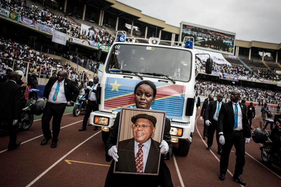 A woman holds the portrait of late former DR Congo Prime Minister and opposition leader Etienne Tshisekedi as his remains arrive at the mourning ceremony.