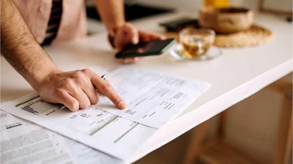 Man looks at bills - stock shot