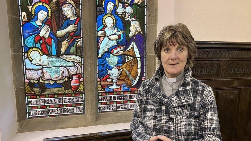 Nia Wyn Morris standing beside the church windows