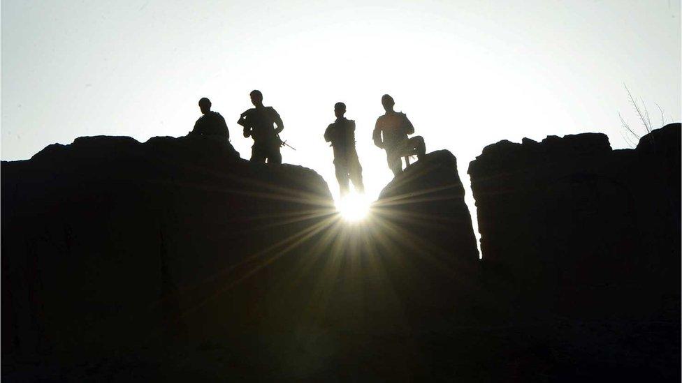 Government soldiers stand guard in Ghor province