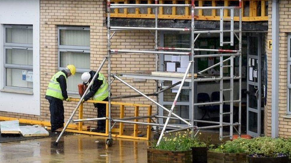 Workers on site at one of the closed schools