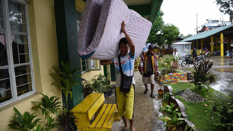 A resident carries a matress inside a classroom used as an evacuation centre as Typhoon Mangkhut approached the city of Tuguegarao